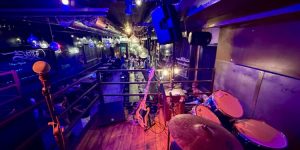 Musiciens partageant un moment de scène ouverte sur une petite scène intimiste de bar