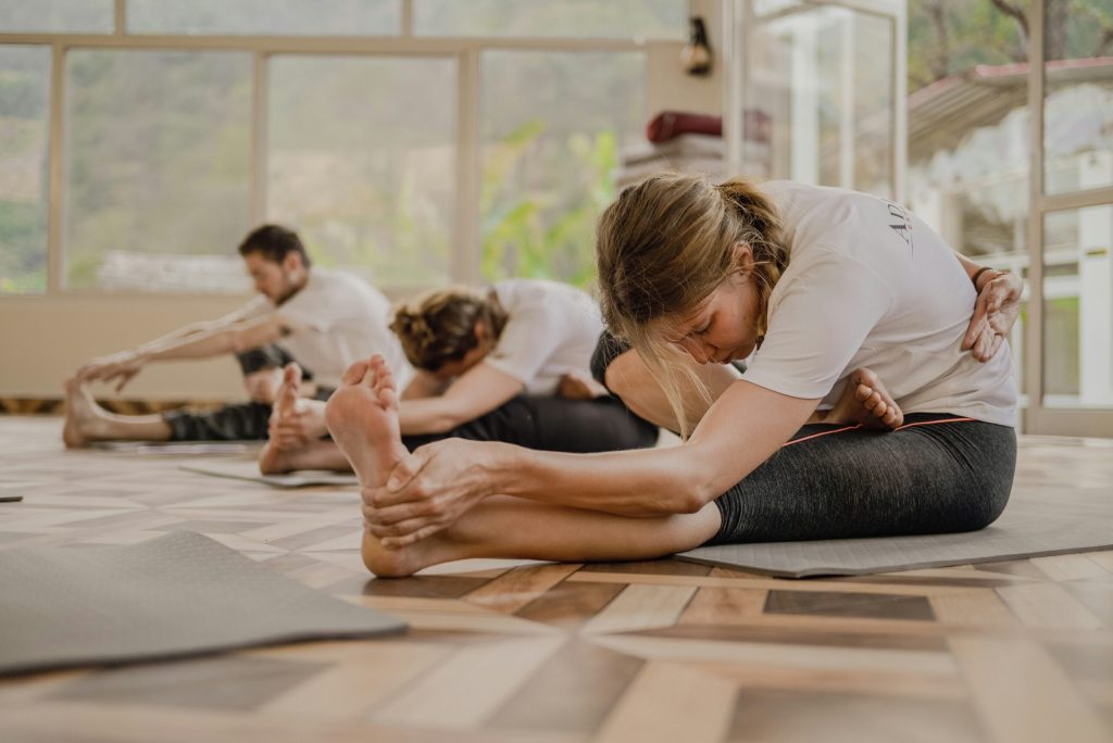 Groupe pratiquant le Pilates sur tapis en intérieur